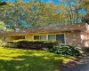 View of property exterior featuring stone siding and a lawn View of property exterior featuring stone siding and a lawn