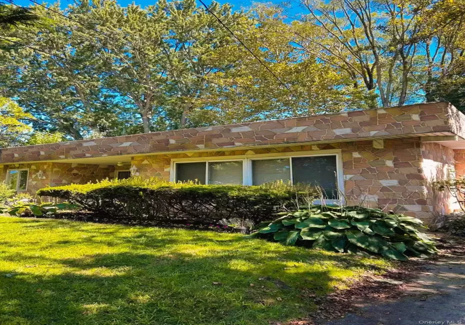 View of property exterior featuring stone siding and a lawn View of property exterior featuring stone siding and a lawn