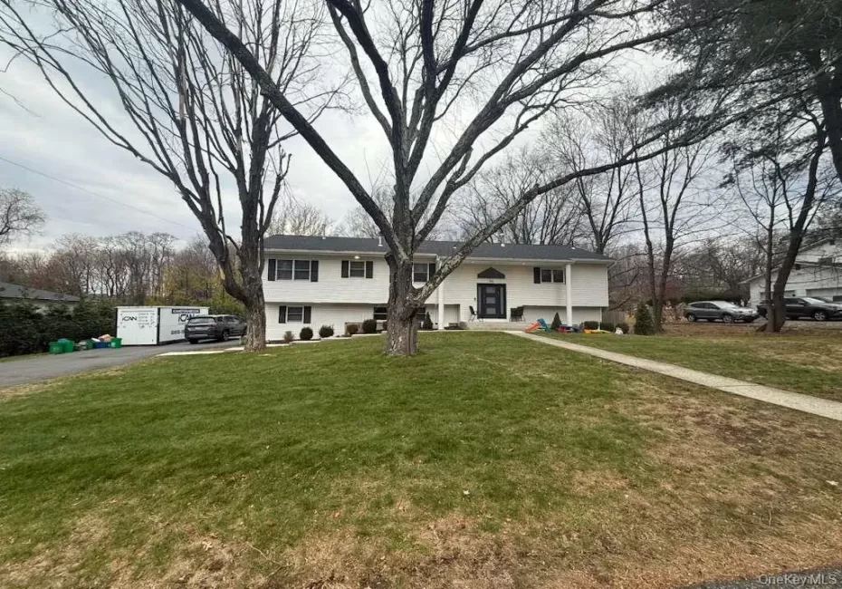 Bi-level home with a front yard and asphalt driveway Bi-level home with a front yard and asphalt driveway