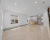 Open-concept living space featuring light wood-finish flooring, recessed lighting, and white baseboards Open-concept living space featuring light wood-finish flooring, recessed lighting, and white baseboards