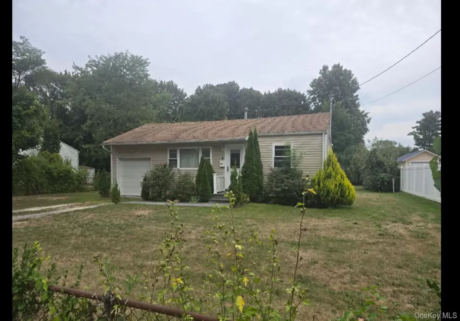 Ranch-style house with an attached garage and view of scattered trees Ranch-style house with an attached garage and view of scattered trees