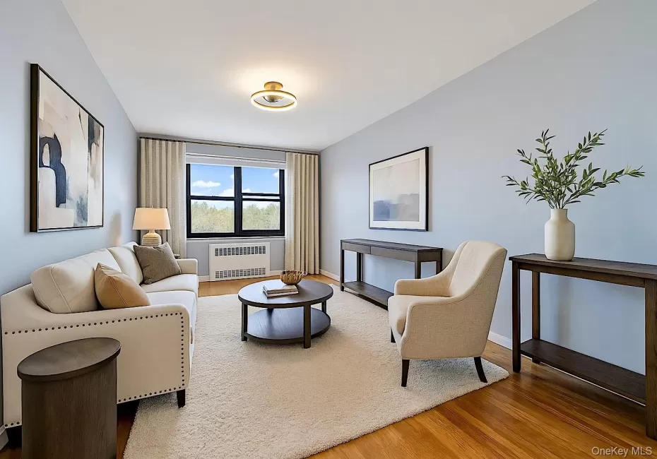 Living area with light wood-style floors and radiator heating unit Living area with light wood-style floors and radiator heating unit