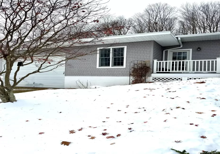 View of snow covered exterior with a wooden deck View of snow covered exterior with a wooden deck