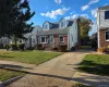 Cape cod house featuring roof with shingles, a front lawn, brick siding, a chimney, and concrete driveway Cape cod house featuring roof with shingles, a front lawn, brick siding, a chimney, and concrete driveway