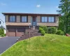 Split-level home featuring cedar shake siding and a brown trim Split-level home featuring cedar shake siding and a brown trim
