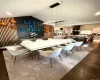 Open-concept dining area featuring dark wood-finish flooring, a modern linear chandelier, and a vaulted ceiling Open-concept dining area featuring dark wood-finish flooring, a modern linear chandelier, and a vaulted ceiling