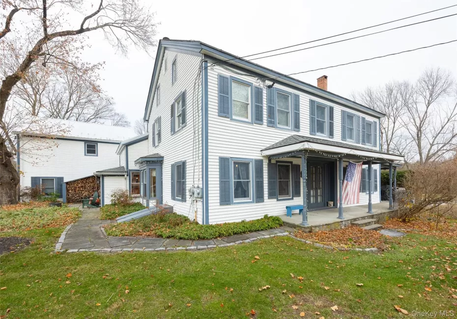View of front of home with a chimney, a front yard, and covered porch View of front of home with a chimney, a front yard, and covered porch