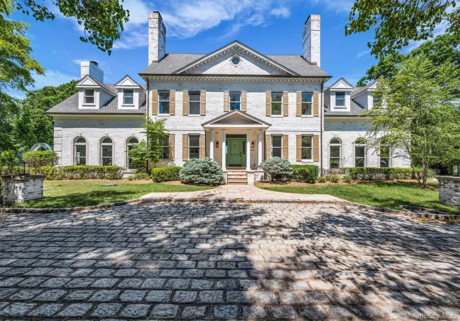 Classic white brick facade with a prominent central entrance, flanked by twin chimneys Classic white brick facade with a prominent central entrance, flanked by twin chimneys
