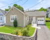 Single-story residence featuring light green siding and a gray shingle roof Single-story residence featuring light green siding and a gray shingle roof