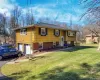 Split-level residence featuring yellow siding and black louvered shutters Split-level residence featuring yellow siding and black louvered shutters