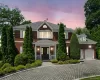 View of front of property with brick siding, decorative driveway, covered porch, a shingled roof, and an attached garage View of front of property with brick siding, decorative driveway, covered porch, a shingled roof, and an attached garage