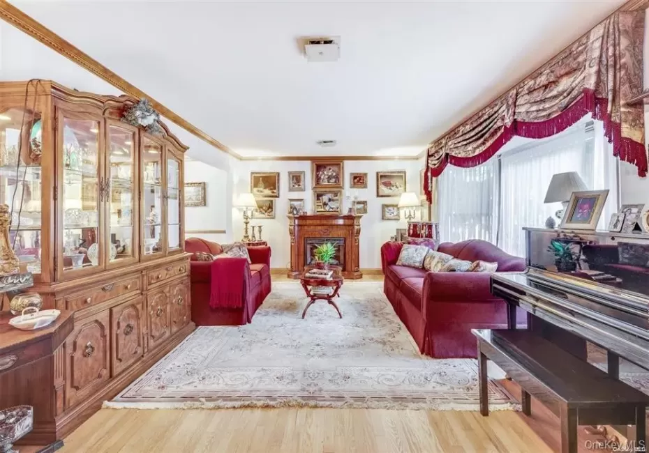 Living area with light wood-type flooring, a fireplace, and crown molding Living area with light wood-type flooring, a fireplace, and crown molding