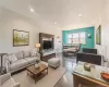 Open-concept living area featuring dark wood-finish flooring, recessed lighting, and a built-in media console Open-concept living area featuring dark wood-finish flooring, recessed lighting, and a built-in media console