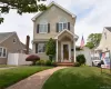 Two-story residence featuring light-colored siding and dark shutters Two-story residence featuring light-colored siding and dark shutters