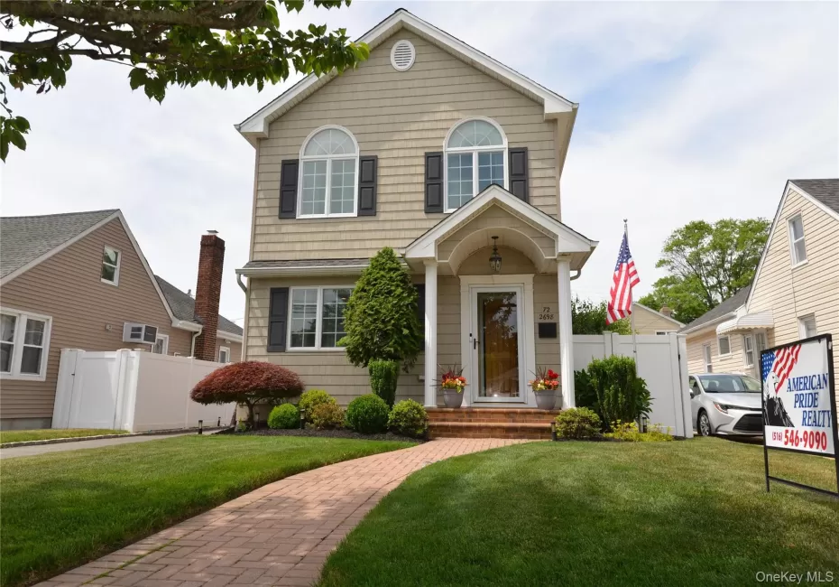 Two-story residence featuring light-colored siding and dark shutters Two-story residence featuring light-colored siding and dark shutters