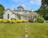 Victorian home featuring a chimney and a porch Victorian home featuring a chimney and a porch