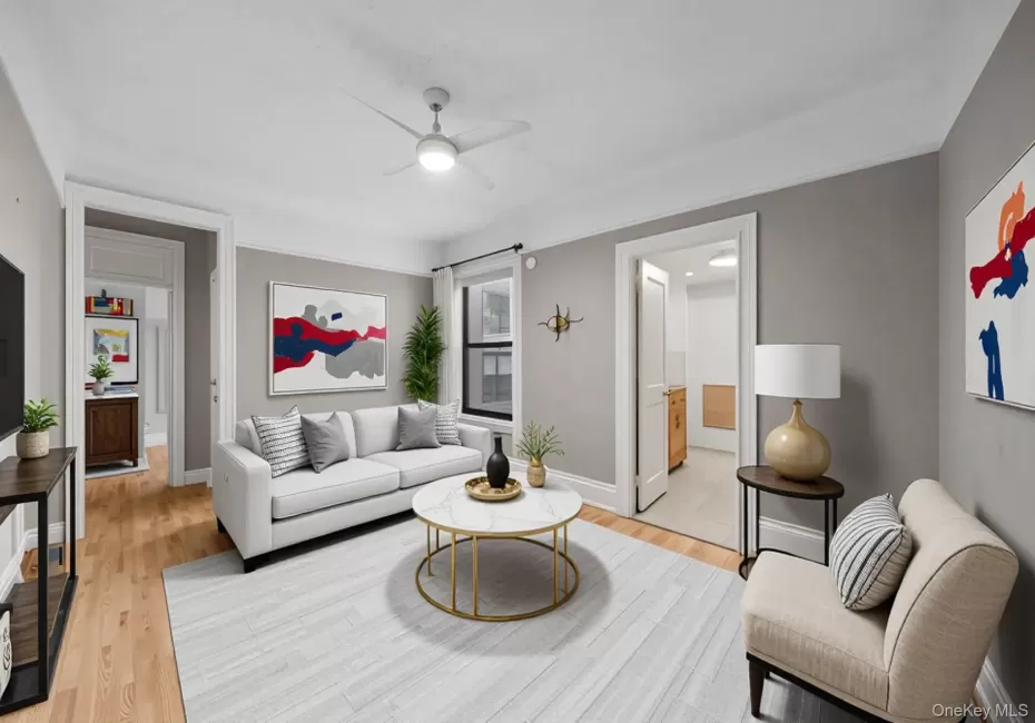 Living room featuring ceiling fan and light wood-style floors Living room featuring ceiling fan and light wood-style floors