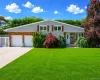 Front exterior featuring a brick and shingle facade, two-car garage, mature landscaping, and an expansive lawn Front exterior featuring a brick and shingle facade, two-car garage, mature landscaping, and an expansive lawn