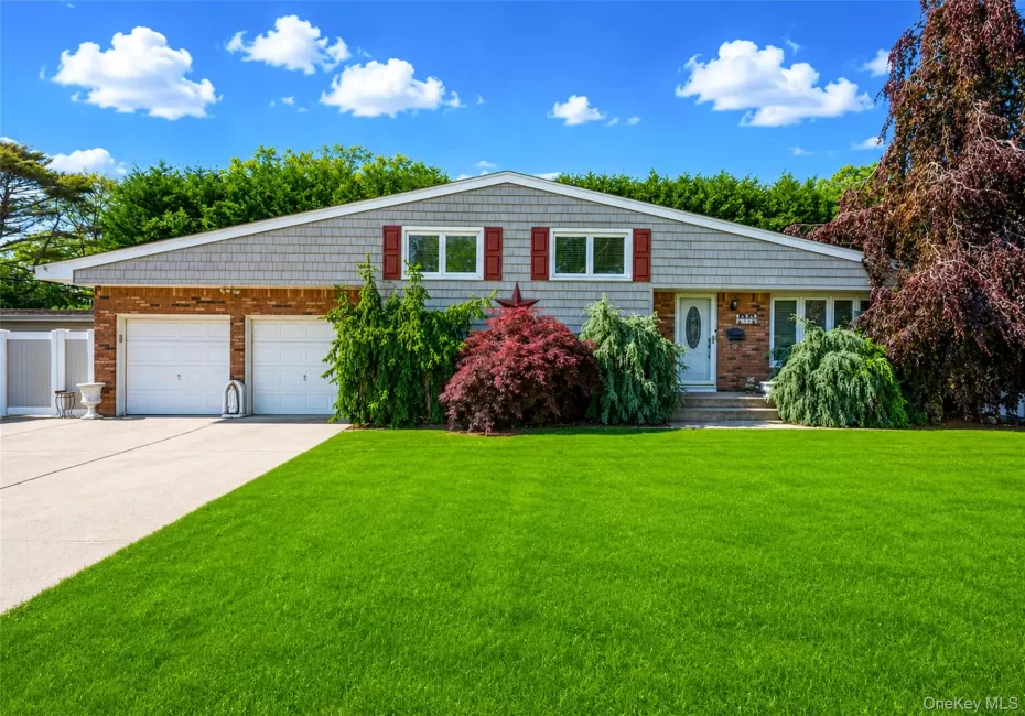 Front exterior featuring a brick and shingle facade, two-car garage, mature landscaping, and an expansive lawn Front exterior featuring a brick and shingle facade, two-car garage, mature landscaping, and an expansive lawn