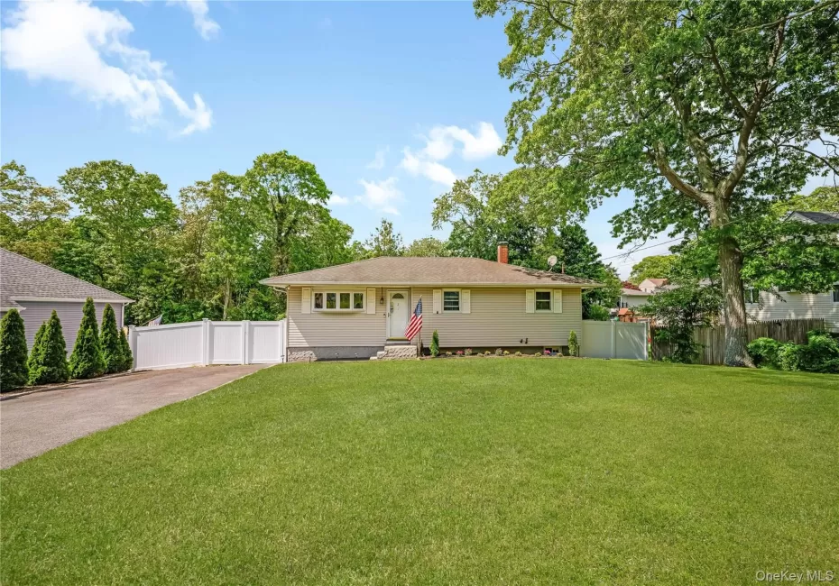 Ranch-style residence featuring a light-colored exterior with a front entry porch and a large front window Ranch-style residence featuring a light-colored exterior with a front entry porch and a large front window