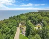 Drone / aerial view of a heavily wooded area and a nearby body of water Drone / aerial view of a heavily wooded area and a nearby body of water