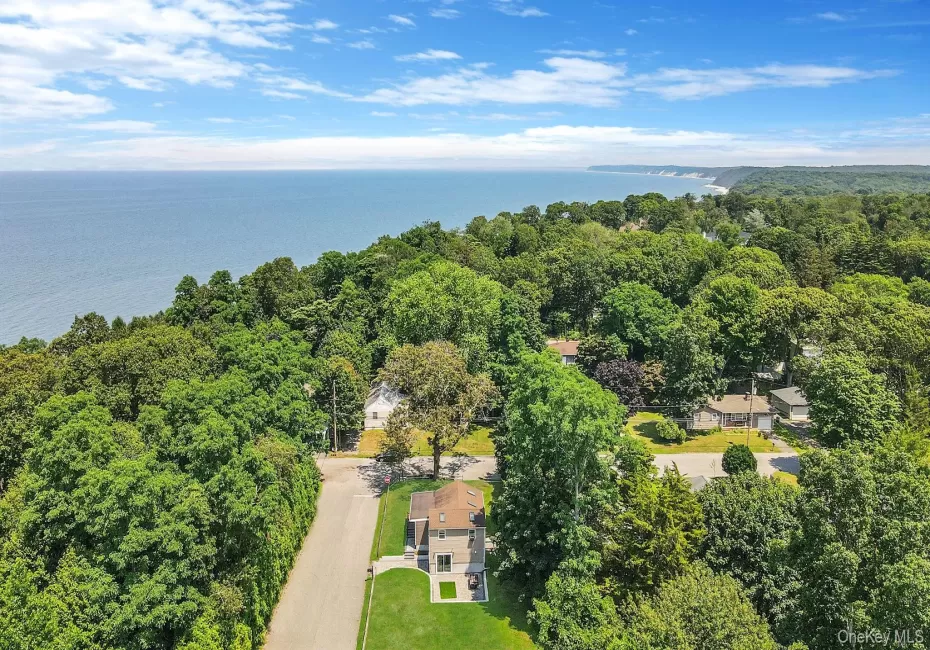 Drone / aerial view of a heavily wooded area and a nearby body of water Drone / aerial view of a heavily wooded area and a nearby body of water