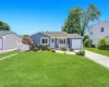 Split Level residence featuring blue siding and a well-maintained front lawn Split Level residence featuring blue siding and a well-maintained front lawn