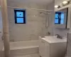 Bathroom featuring a white subway tile surround with subtle veining, complete with a white bathtub, and brushed nickel shower fixtures Bathroom featuring a white subway tile surround with subtle veining, complete with a white bathtub, and brushed nickel shower fixtures