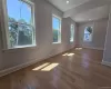 Spacious room featuring light wood-finish flooring, ample natural light from multiple windows, recessed ceiling lighting, crisp white baseboards, and neutral wall tones Spacious room featuring light wood-finish flooring, ample natural light from multiple windows, recessed ceiling lighting, crisp white baseboards, and neutral wall tones