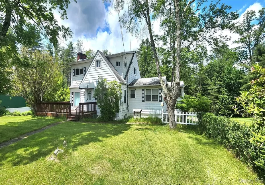 Rear view of house with a chimney and a deck Rear view of house with a chimney and a deck