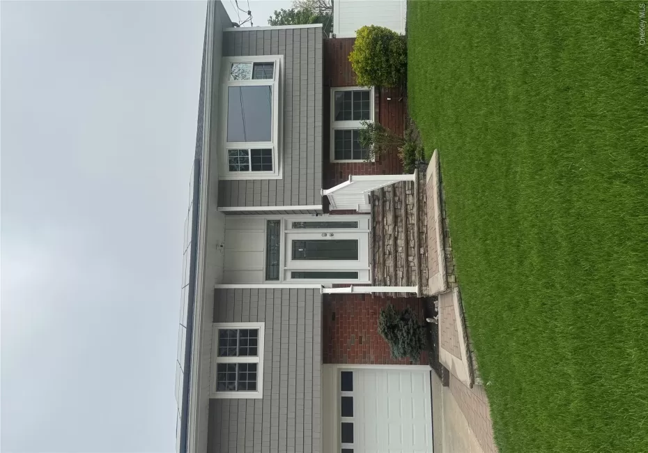 Split-level residence featuring gray shake siding and red brick accents Split-level residence featuring gray shake siding and red brick accents