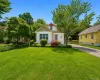 Charming white-sided residence featuring a gabled roofline and an attic Charming white-sided residence featuring a gabled roofline and an attic