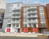 Modern multi-story building featuring a facade of grey and brown paneling Modern multi-story building featuring a facade of grey and brown paneling