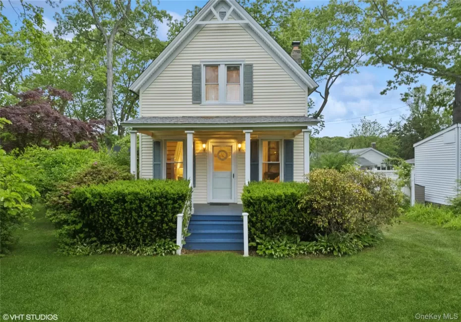 View of front facade with a chimney, a porch, a front lawn, and roof with shingles View of front facade with a chimney, a porch, a front lawn, and roof with shingles