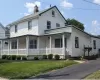 View of front of home featuring covered porch, a chimney, a front lawn, and cooling unit View of front of home featuring covered porch, a chimney, a front lawn, and cooling unit