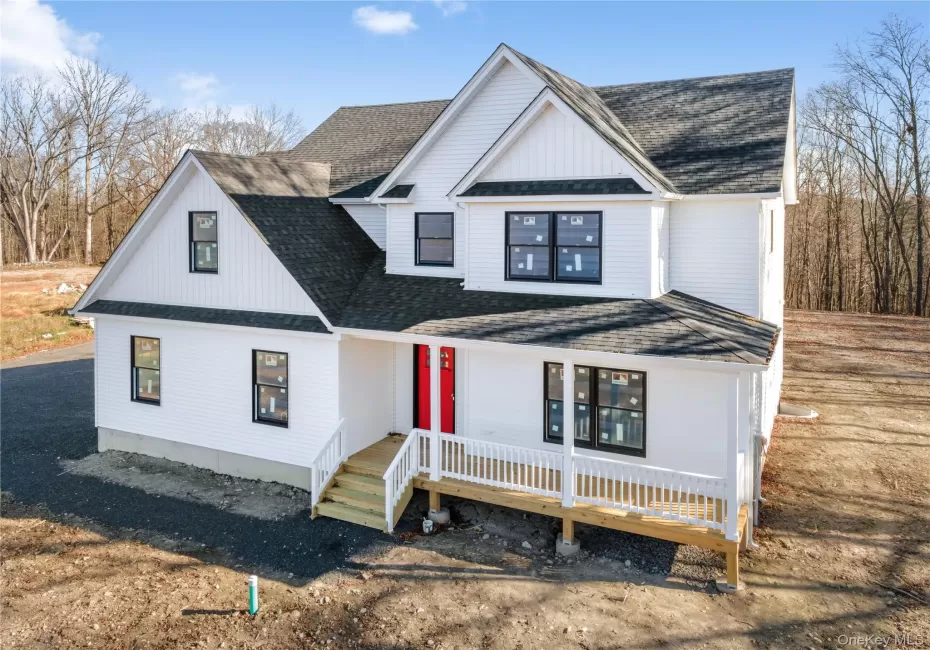 Modern farmhouse featuring a shingled roof and covered porch Modern farmhouse featuring a shingled roof and covered porch
