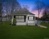 The property features a well-maintained lawn and a white exterior with dark shutters The property features a well-maintained lawn and a white exterior with dark shutters