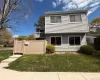 Two-story residence featuring light gray horizontal siding and white trim Two-story residence featuring light gray horizontal siding and white trim