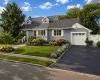 Cape Cod-style residence featuring light blue siding and a dark gray shingle roofDigitally enhanced photo showing landscape options Cape Cod-style residence featuring light blue siding and a dark gray shingle roofDigitally enhanced photo showing landscape options