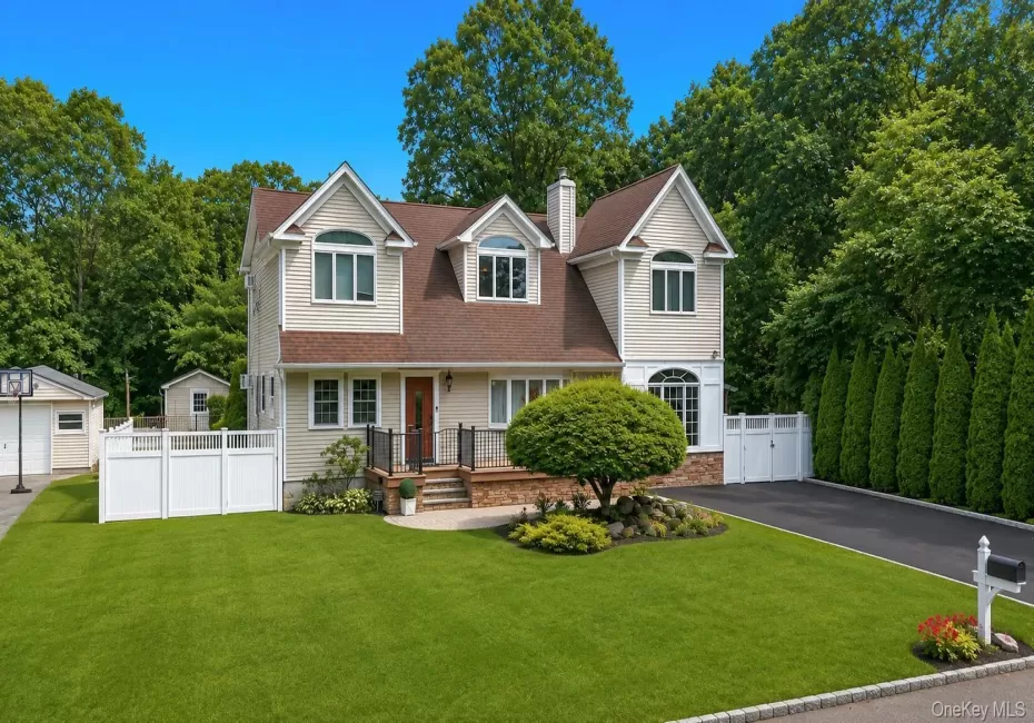 Two-story residence featuring light-toned siding, a brown shingle roof, and multiple dormer windows Two-story residence featuring light-toned siding, a brown shingle roof, and multiple dormer windows