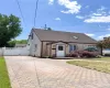 Exterior featuring shingle siding, a multi-tone paver driveway, and a fenced yard Exterior featuring shingle siding, a multi-tone paver driveway, and a fenced yard