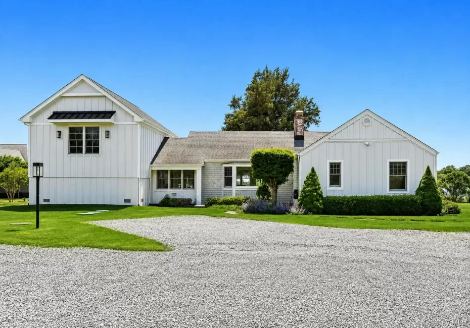 Gravel driveway leading to a multi-gable exterior with a board and batten facade and horizontal siding Gravel driveway leading to a multi-gable exterior with a board and batten facade and horizontal siding