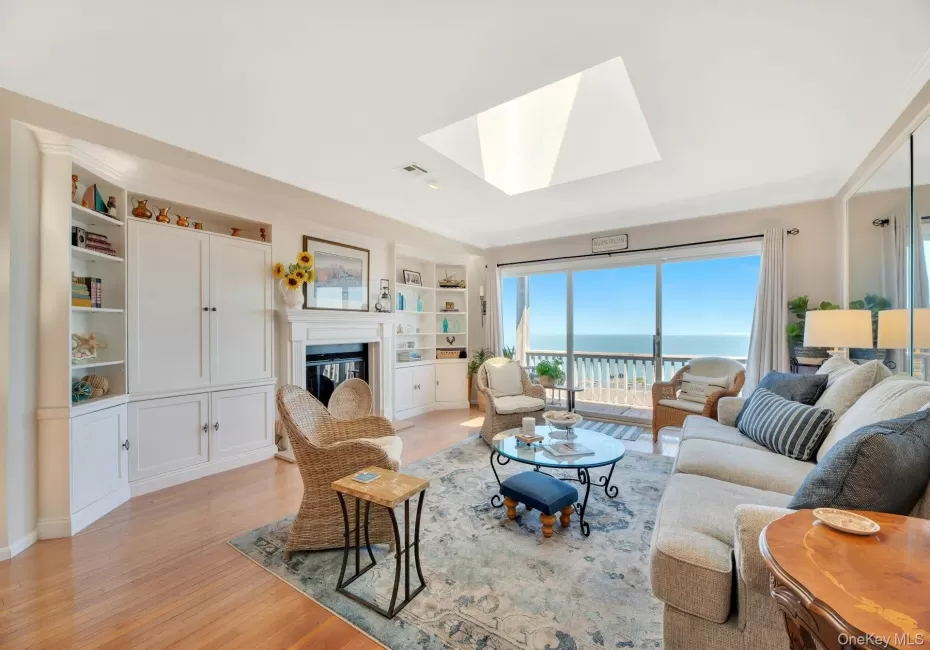 Living room. with wood burning fireplace, skylight, wood floors and amazing views of the Long Island Sound! Living room. with wood burning fireplace, skylight, wood floors and amazing views of the Long Island Sound!