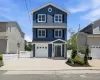 Three-story residence featuring blue siding with white trim and black shutters Three-story residence featuring blue siding with white trim and black shutters