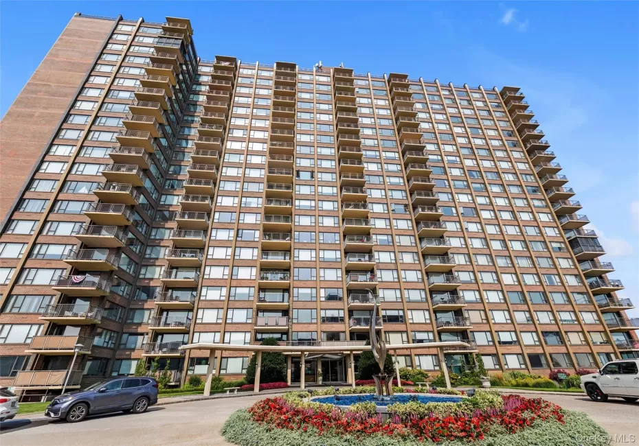 High-rise building featuring a brick facade and numerous private balconies High-rise building featuring a brick facade and numerous private balconies