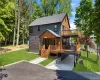 Modern multi-level residence featuring dark siding, natural wood accents, and a tiered deck system Modern multi-level residence featuring dark siding, natural wood accents, and a tiered deck system