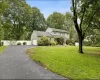 Traditional-style house with driveway, an attached garage, and view of scattered trees Traditional-style house with driveway, an attached garage, and view of scattered trees