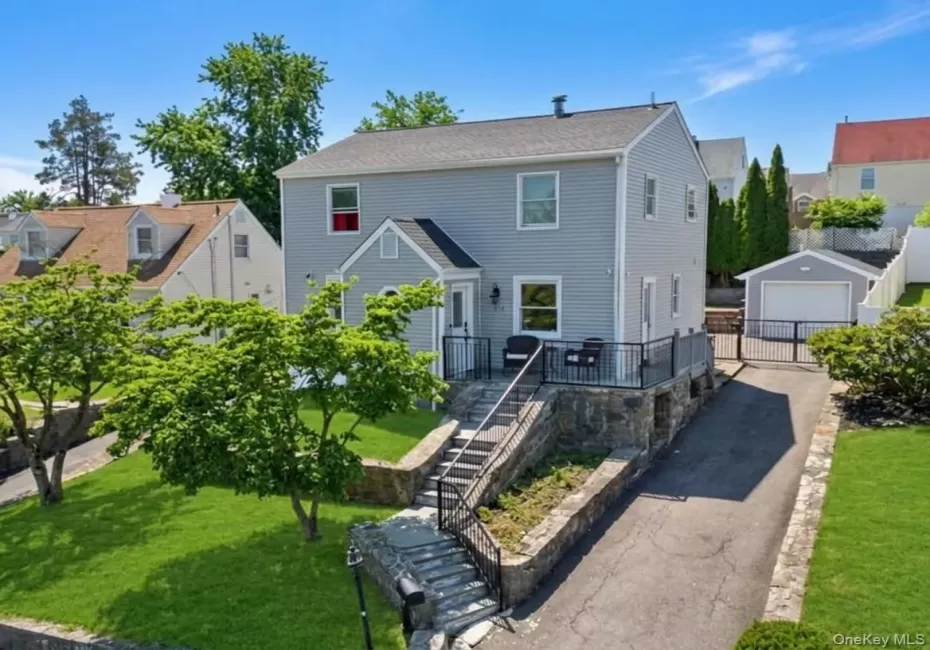 Two-story residence featuring light gray siding and a dark gray roof Two-story residence featuring light gray siding and a dark gray roof