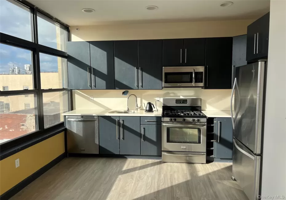 Kitchen featuring sink, light hardwood / wood-style flooring, stainless steel appliances, and a healthy amount of sunlight Kitchen featuring sink, light hardwood / wood-style flooring, stainless steel appliances, and a healthy amount of sunlight