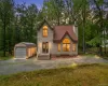 Modern rustic home featuring a light-colored exterior, an arched window, and a dark brown shingle roof Modern rustic home featuring a light-colored exterior, an arched window, and a dark brown shingle roof